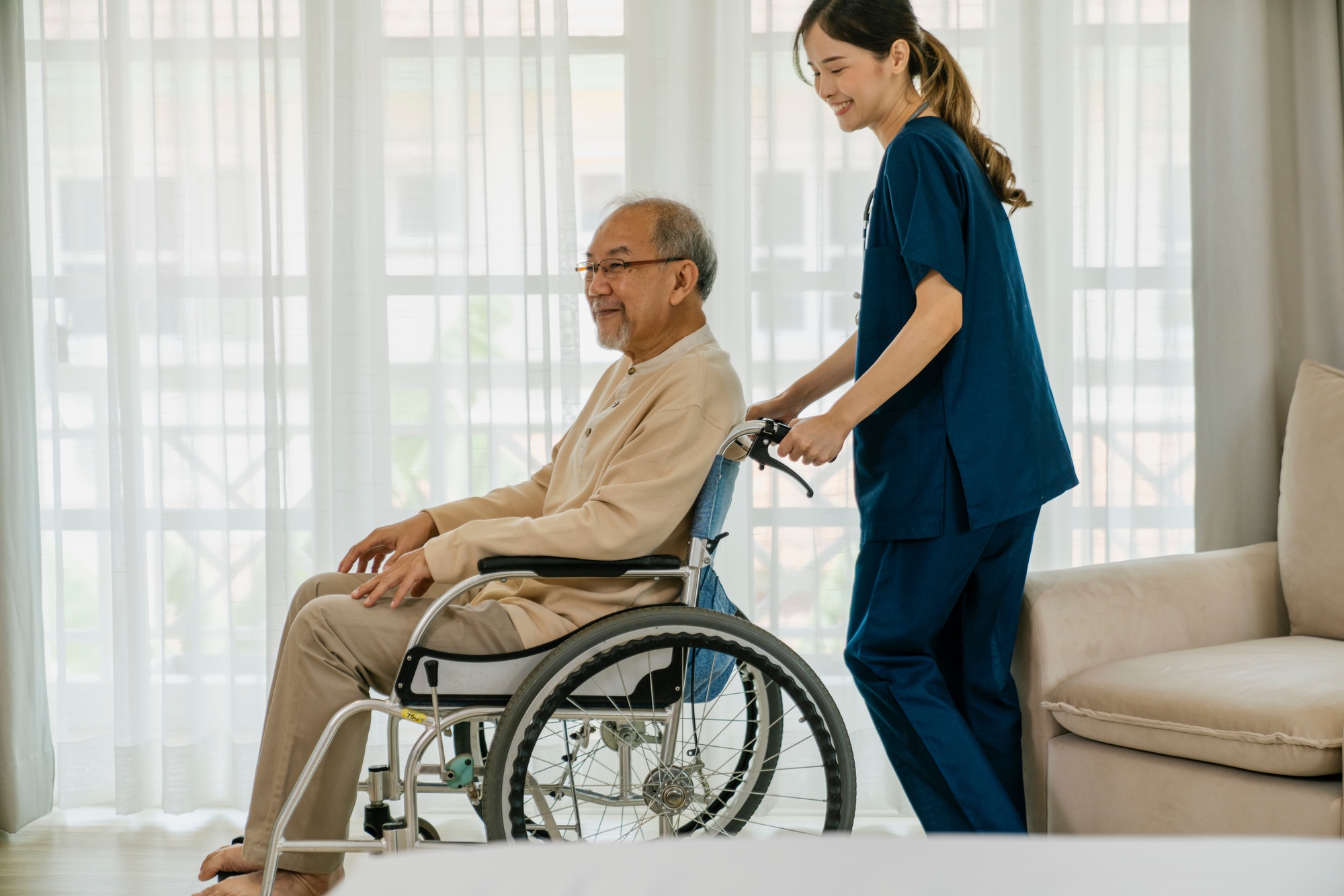 Elderly man with caregiver in nursing home.